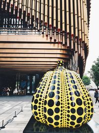 Close-up of yellow umbrella on street against buildings