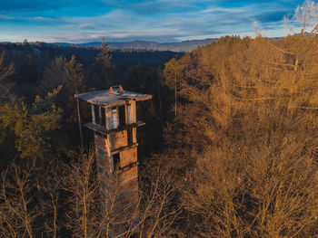 Built structure on field by trees against sky