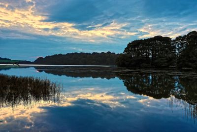 Scenic view of lake against sky at sunset