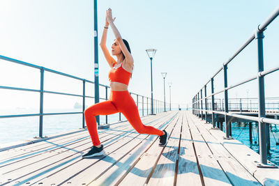 Low angle view of woman walking on pier