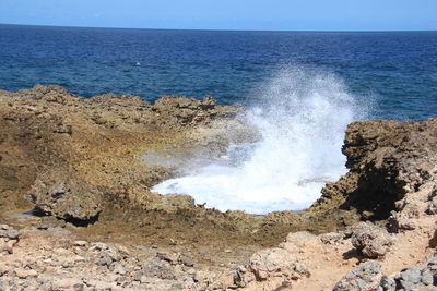 Scenic view of rocks on beach against sky