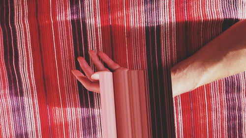Close-up of hand on red curtain