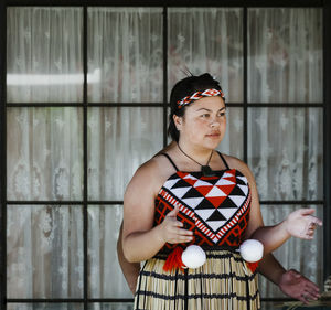 Portrait of senior woman standing against wall