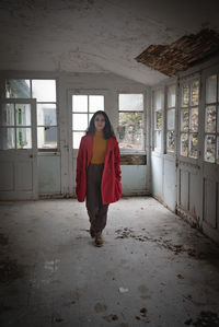 Full length of woman standing by window in building