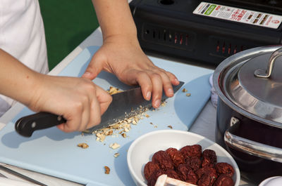 Cropped image of chef chopping nuts at table during cooking competition