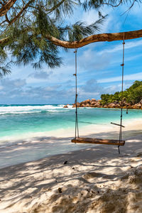 Empty wooden swing on paradise beach on tropical island