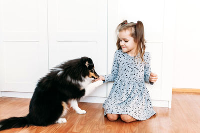 Girl looking away while standing on hardwood floor