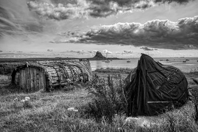 Old wooden structure on field against sky