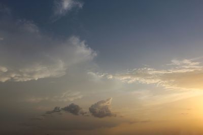 Low angle view of sunlight streaming through clouds