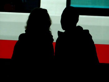 Close-up of people sitting on wall