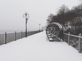 Snow covered street against sky