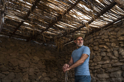 Adult man in cowboy hat and jean in a rural area