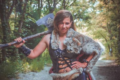 Portrait of young woman standing in forest