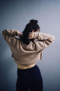 Woman standing against gray background