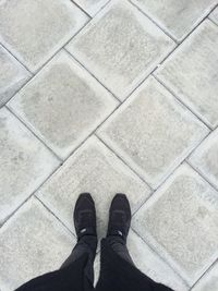 Low section of man standing on tiled floor