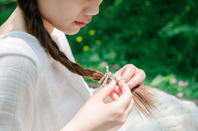 Close-up of young woman tying hair