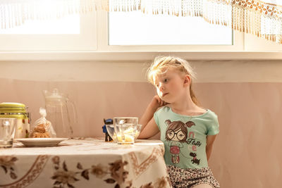 Girl holding ice cream on table