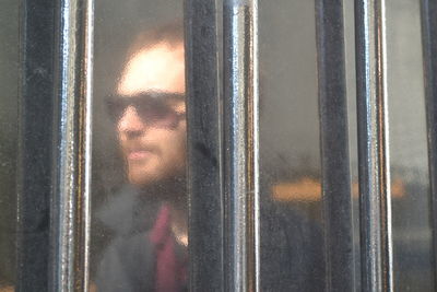 Close-up of person looking through window