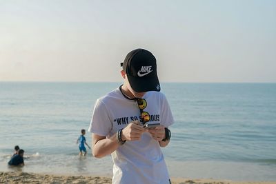 Man standing at beach against sky