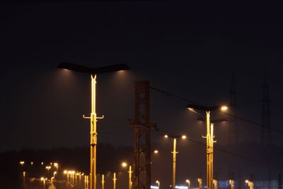 Low angle view of illuminated street lights against clear sky