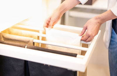 The female hand arranges clothes for neat and orderly in the closet in the bedroom.