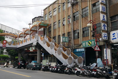 Vehicles parked on street by buildings in city