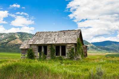 Abandoned house on field against sky