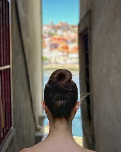 Rear view of woman with hair bun amidst buildings