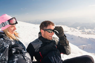 Happy mid adult couple looking away on snowcapped mountain