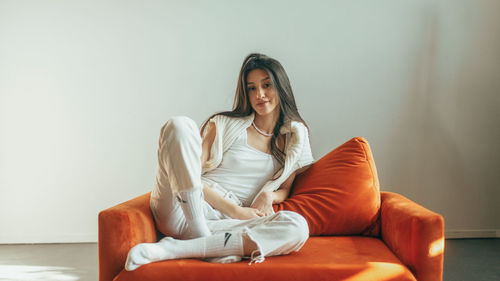 Young woman sitting on sofa at home