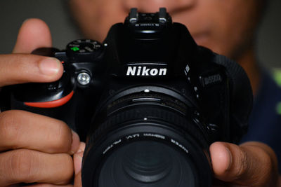 Cropped image of man photographing with camera