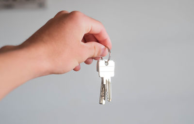 Close-up of person hand holding lamp against white background