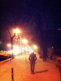 Woman walking on road at night