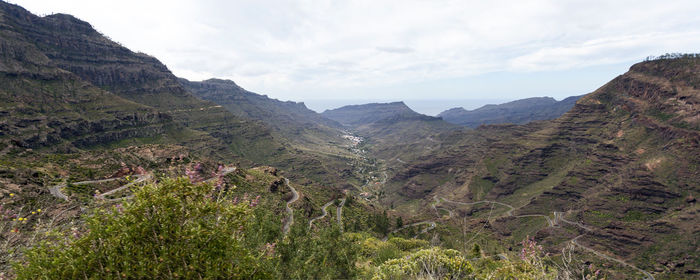 Scenic view of mountains against cloudy sky