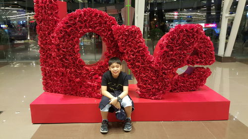 Full length portrait of happy girl sitting outdoors
