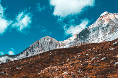 Low angle view of snowcapped mountains against sky