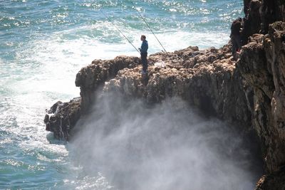 High angle view of man fishing by sea