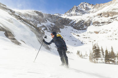 Hiker battles wind above black lake, rocky mountain national park