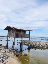 Abandoned house on beach against sky