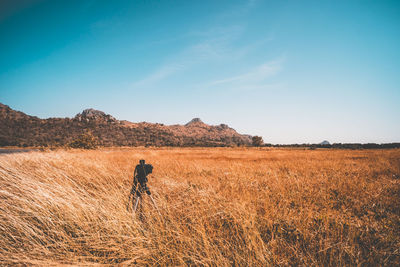 Man standing on field against sky