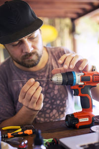 Man repairing drill in workshop