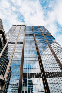 Low angle view of modern glass building against sky
