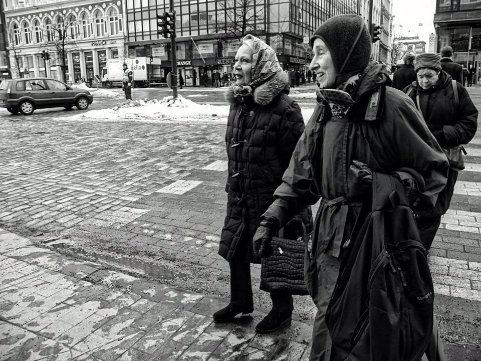 PEOPLE STANDING ON FOOTPATH BY STREET