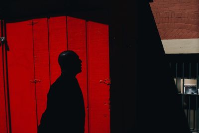 Shadow of man on red door