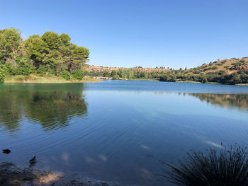 Scenic view of lake against clear blue sky