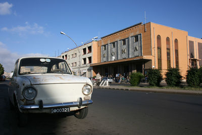 Car on street against buildings in city