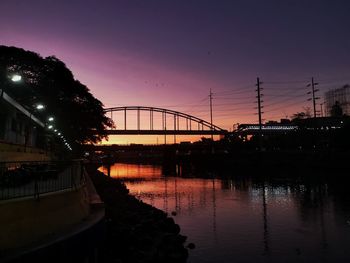 Bridge over river against sky during sunset