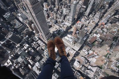 Low section of woman walking on modern buildings in city