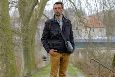 Portrait of man standing against trees