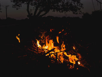 Silhouette of bonfire on field at night